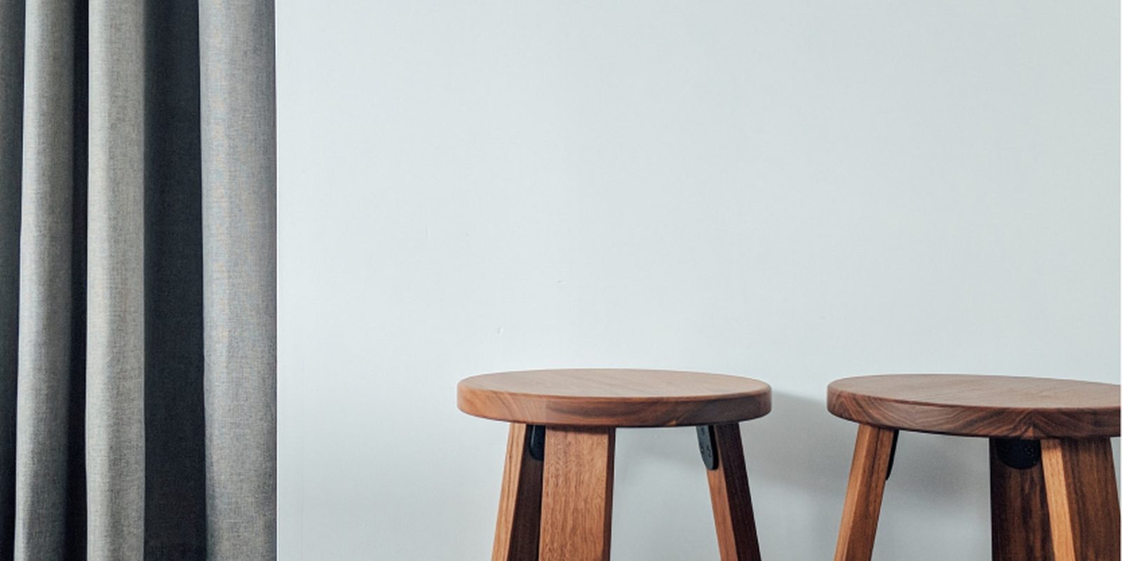 Two wooden stools in a calm, bright room